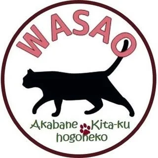 「WASAO Akabane Kita-ku hogoneko」と書かれたロゴマークです。黒い猫のシルエットが中央に描かれ、その下に足跡のアイコンがあります。保護猫活動に関連するデザインと推測されます。