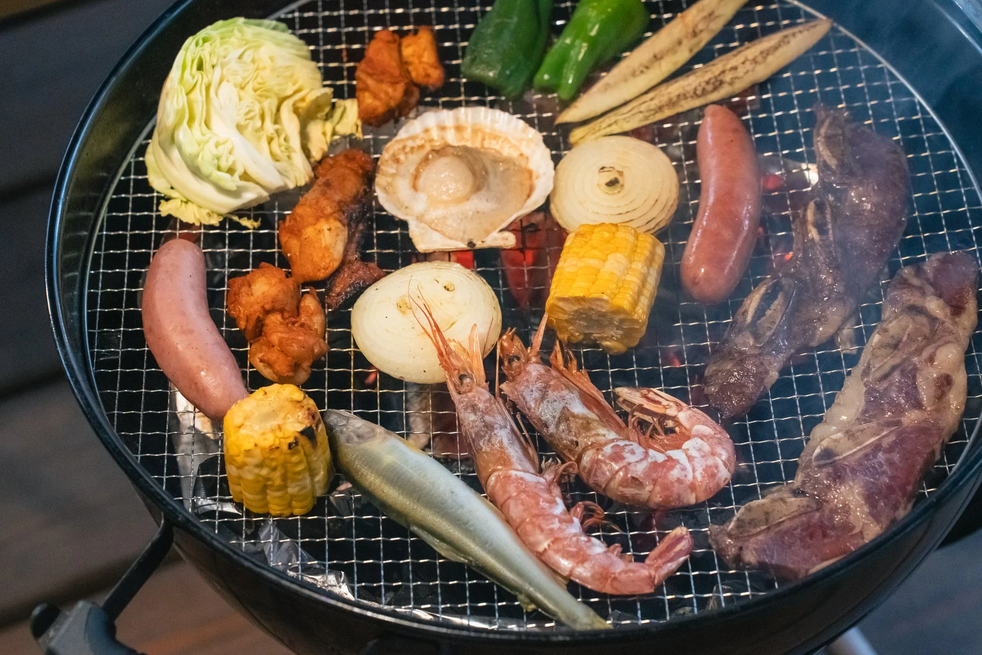 美味しそうな食材が焼かれるBBQグリルの様子