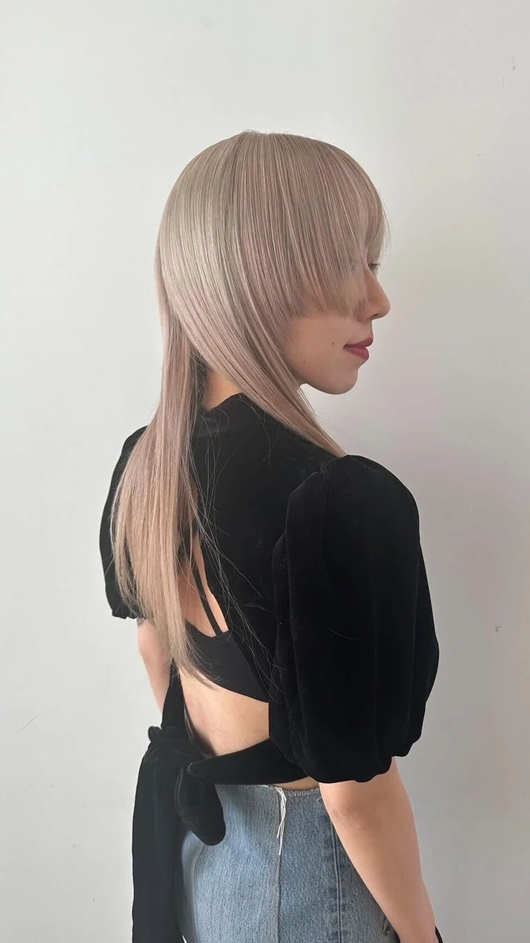 女性、ヘアスタイル、ロングヘア、ブロンド、アッシュブロンド、姫カット、ウルフカット、前髪、黒トップス、背中開き、ジーンズ、ファッション、横顔、ヘアカラー