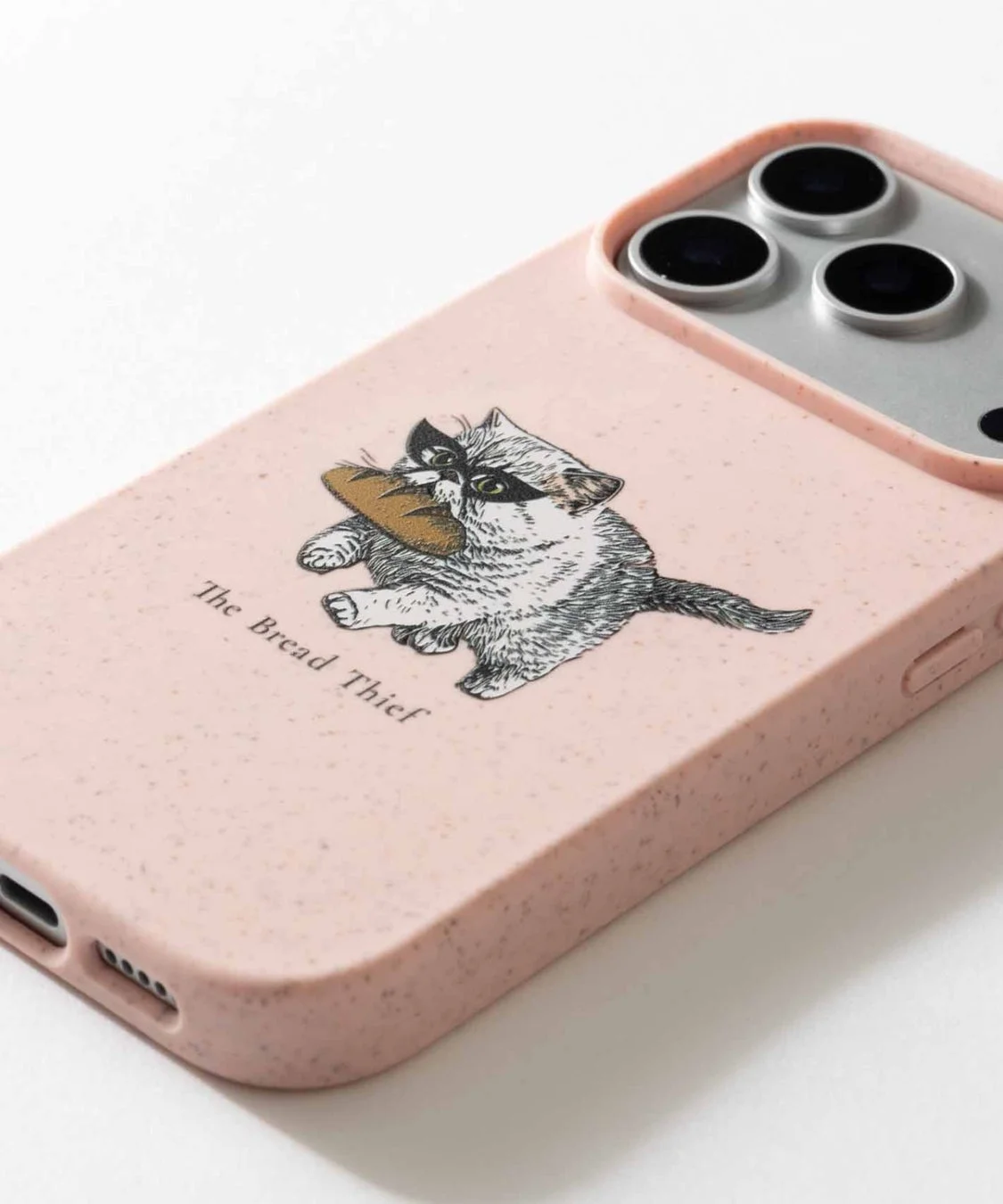 ピンク色のiPhoneケースに、バゲットをくわえたかわいらしい猫のイラストが描かれています。「The Bread Thief」という文字もデザインされており、ユニークな印象です。