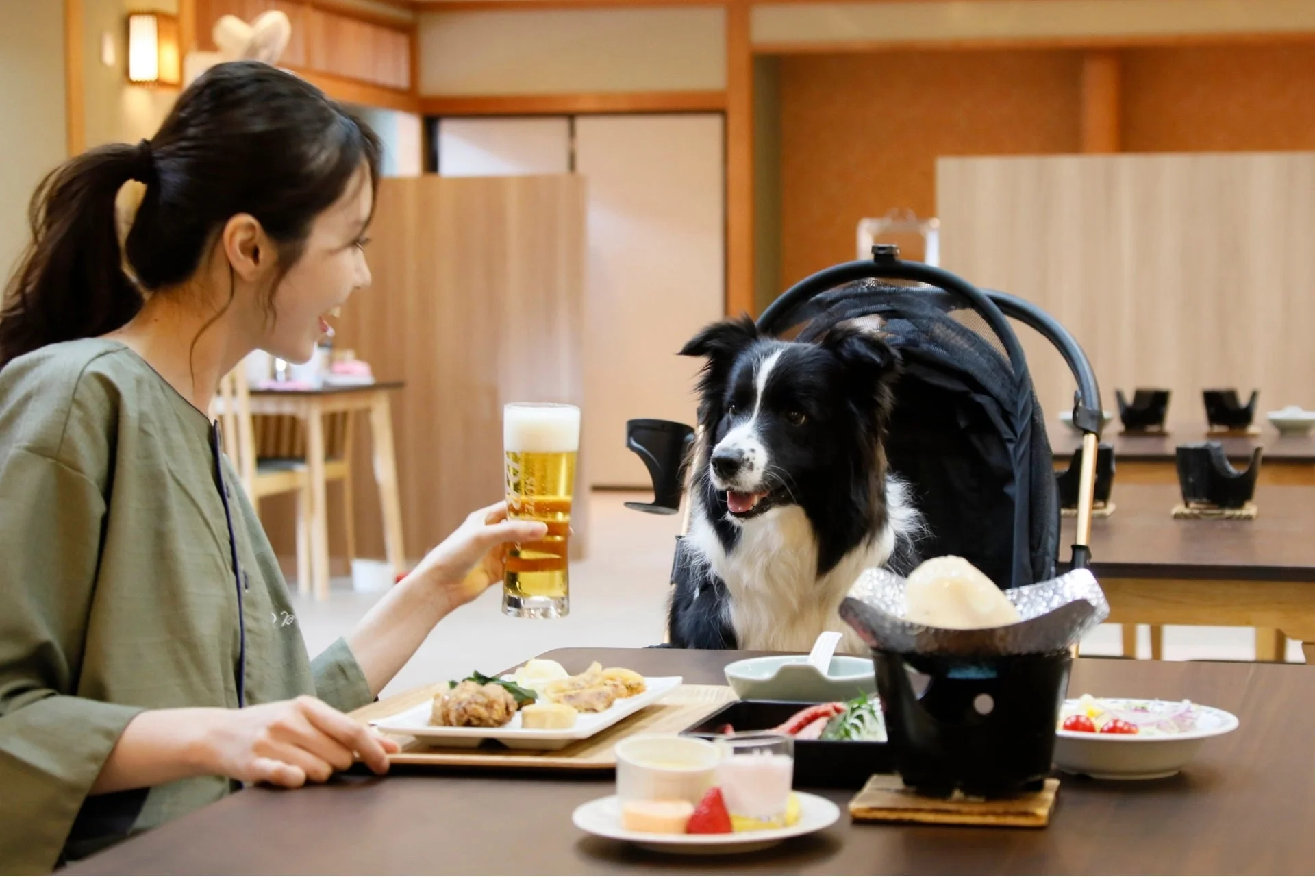 レストランで愛犬と食事を楽しむ女性