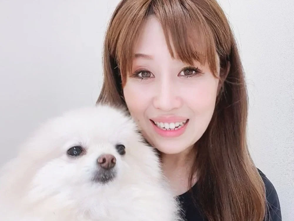 ポメラニアンを抱っこして笑顔の女性