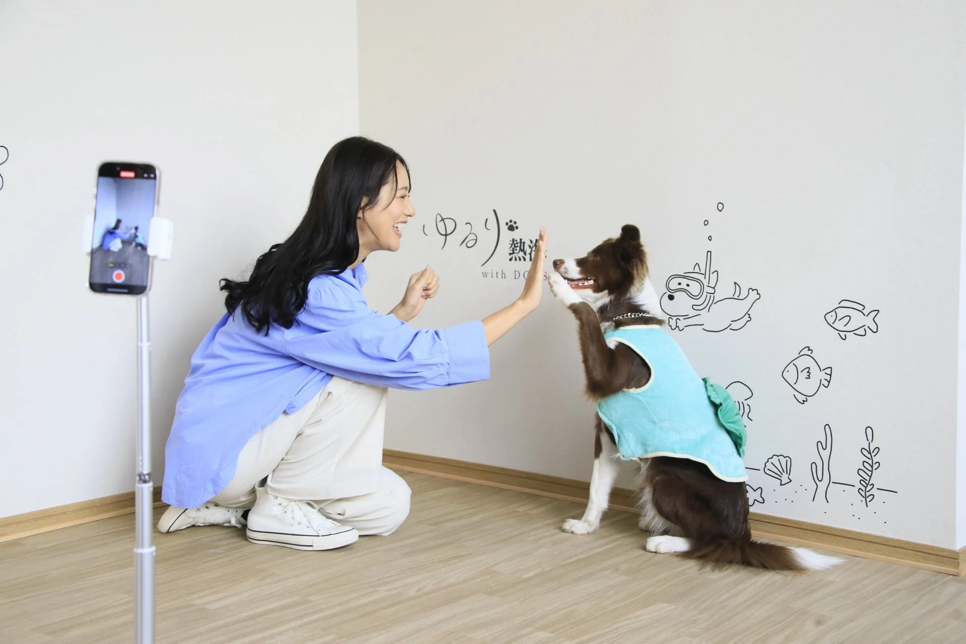 女性と犬がハイタッチする