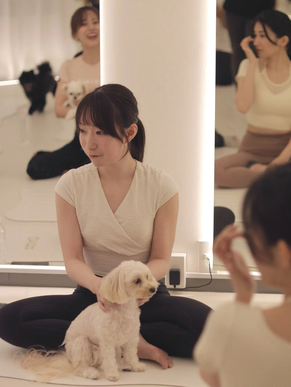 女性が犬を撫でているヨガ風景