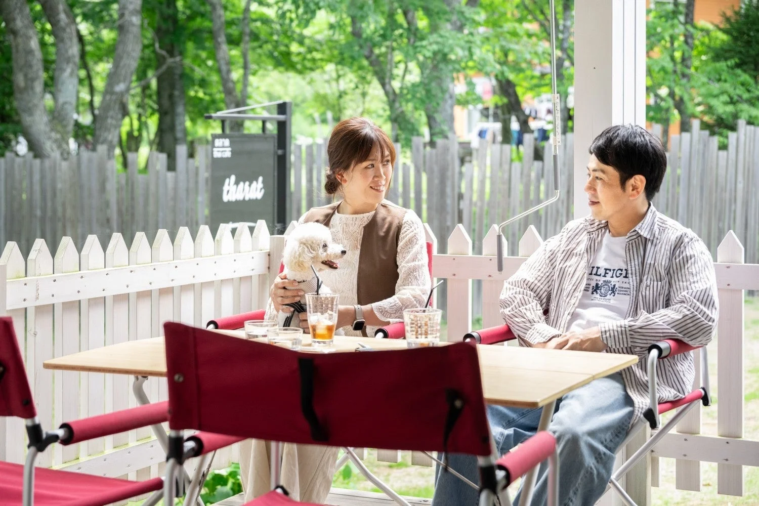 屋外カフェで夫婦と犬