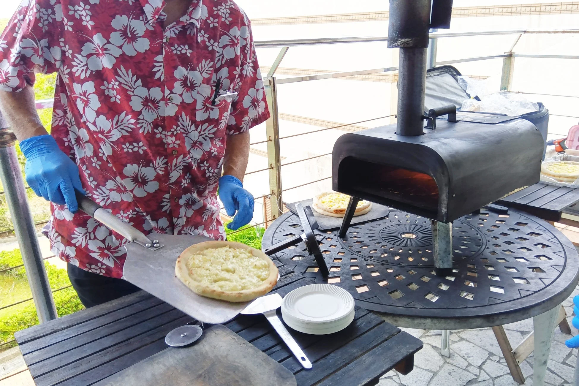 屋外のピザ窯でピザを焼く様子