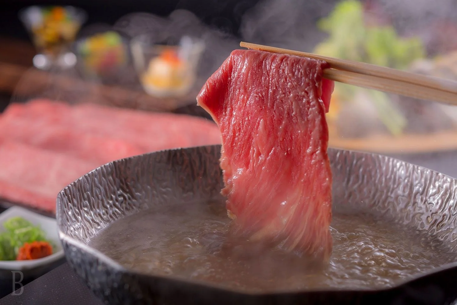 湯気の立つ鍋で調理される牛肉