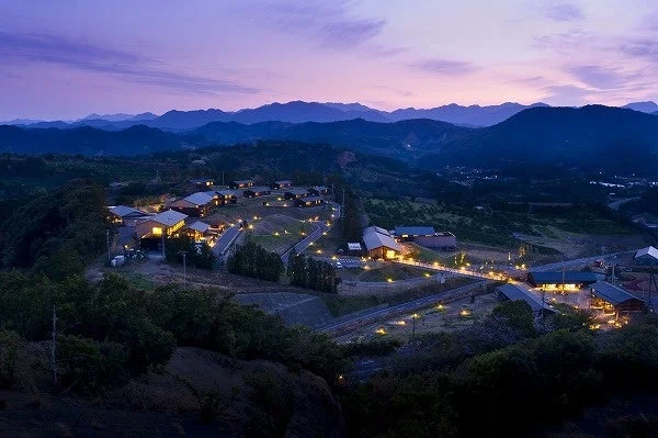 夕暮れの山間部に広がる集落のような風景