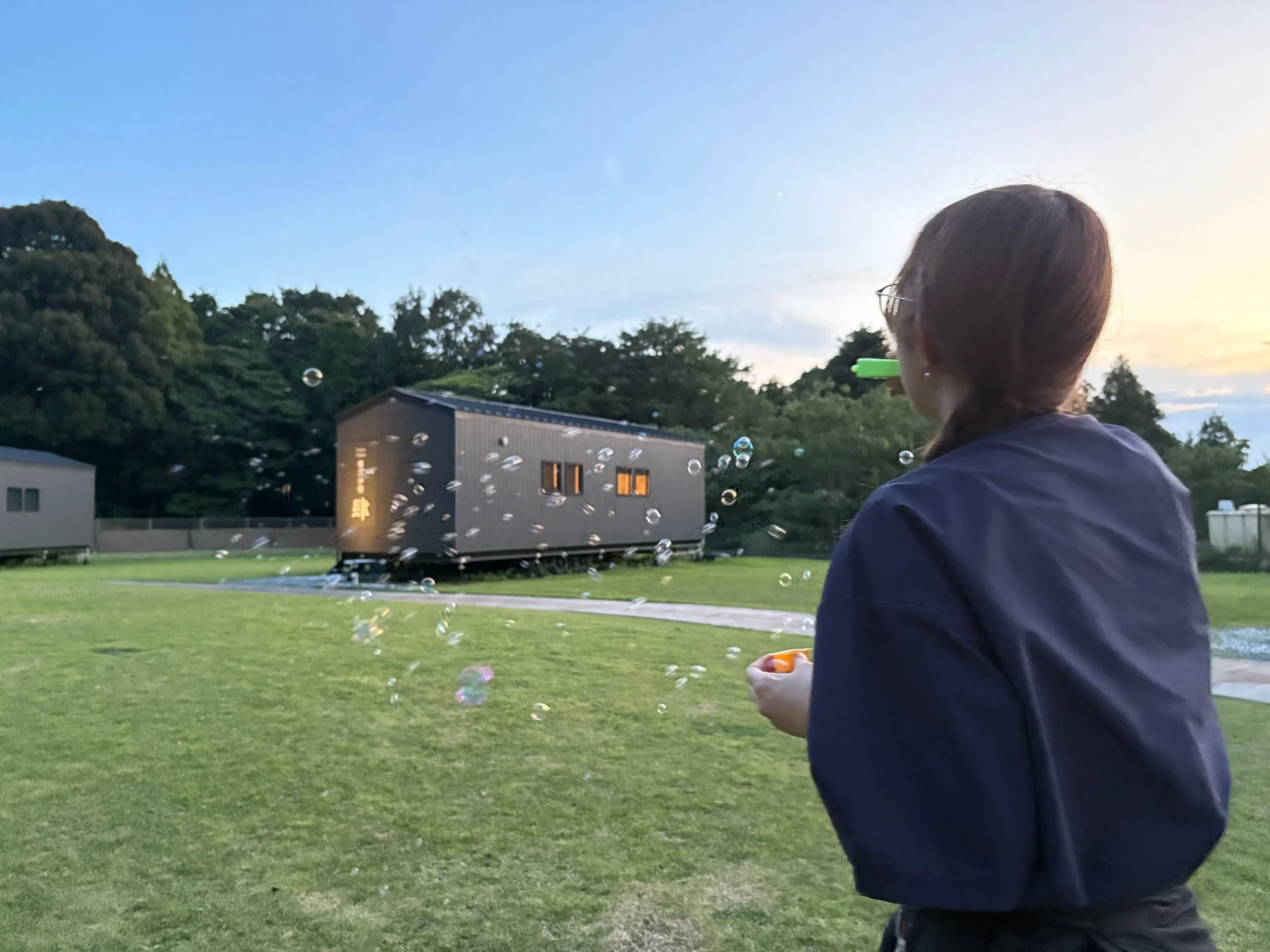 夕暮れの屋外でシャボン玉を楽しむ女性