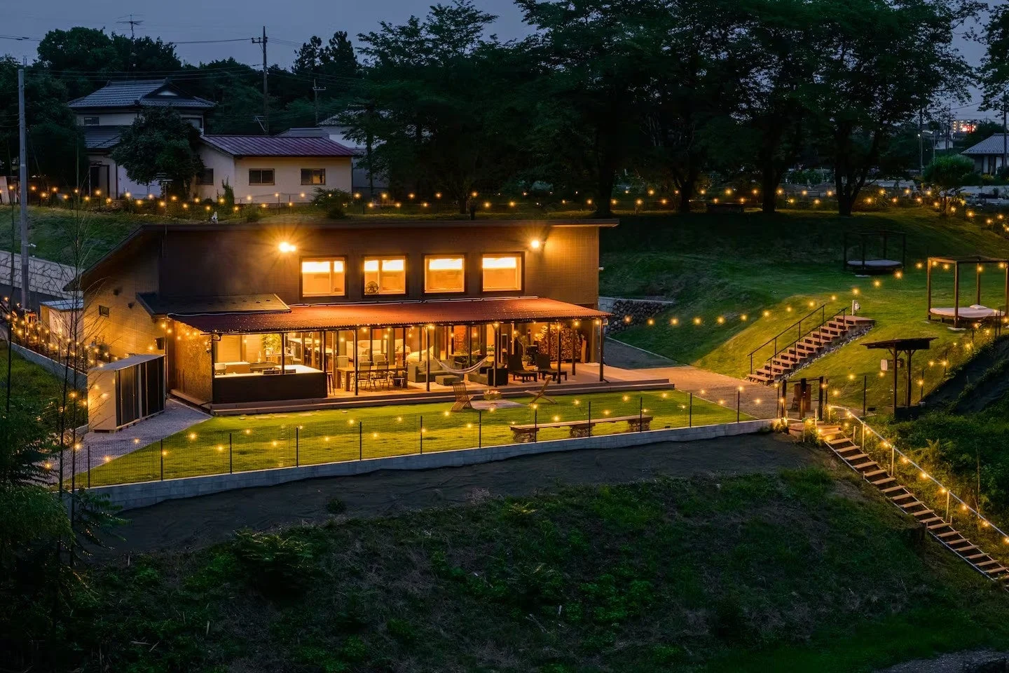 広々とした芝生とモダンな住宅の夜景