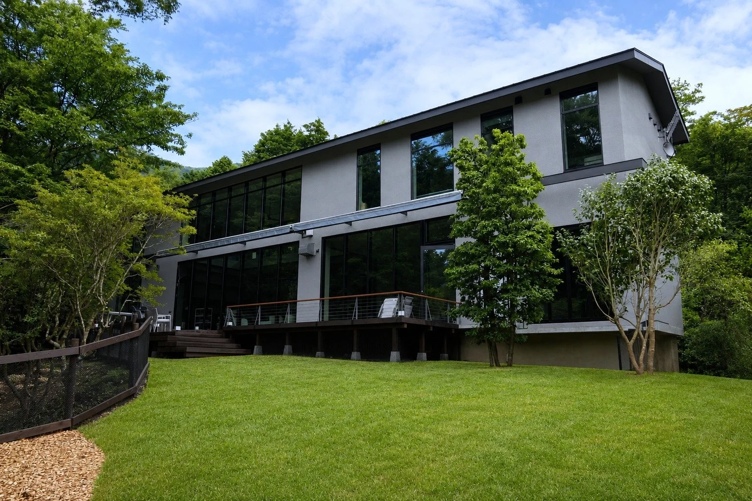 緑に囲まれたモダンな建物と広大な庭