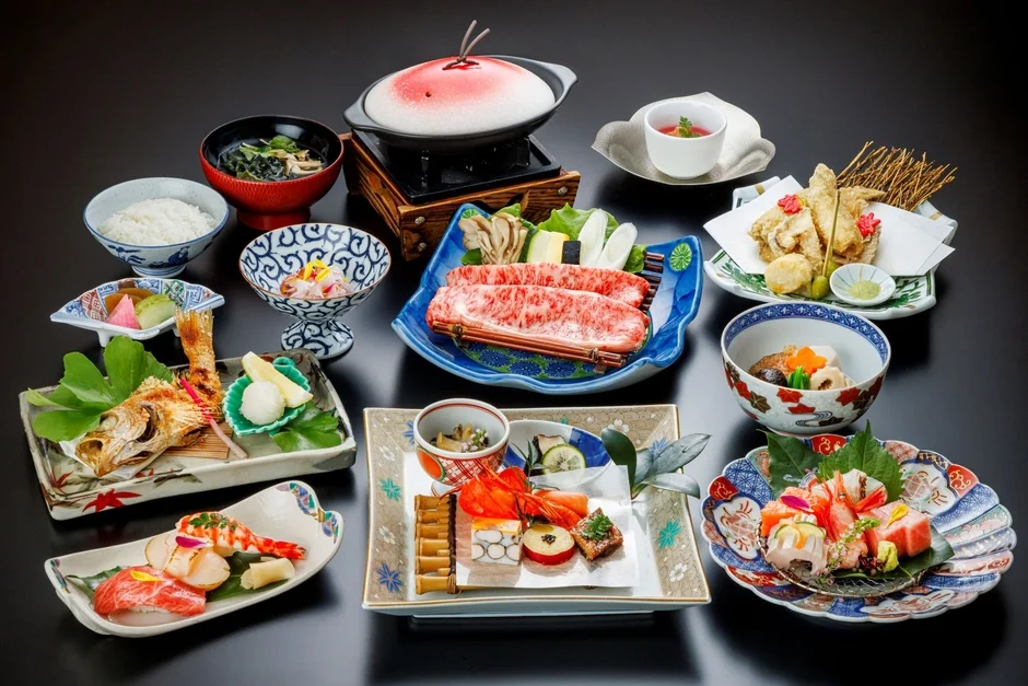 黒い背景に豪華な日本料理が多数並べられた一枚