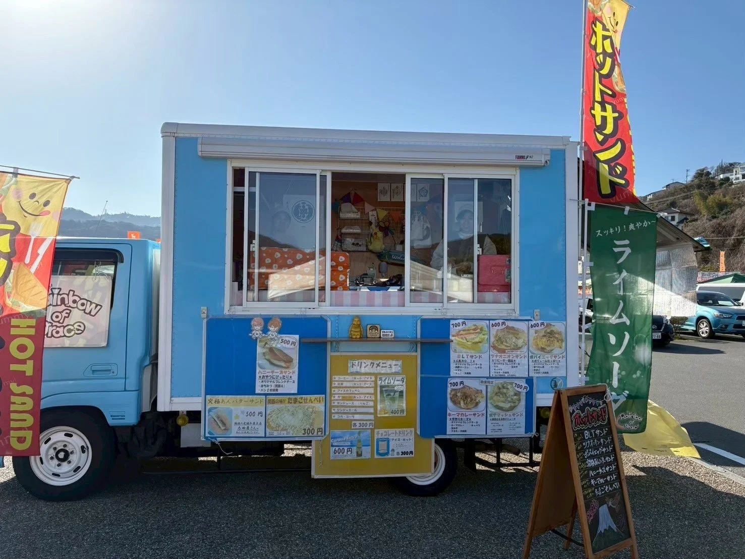 青い移動販売車でホットサンドを販売する様子