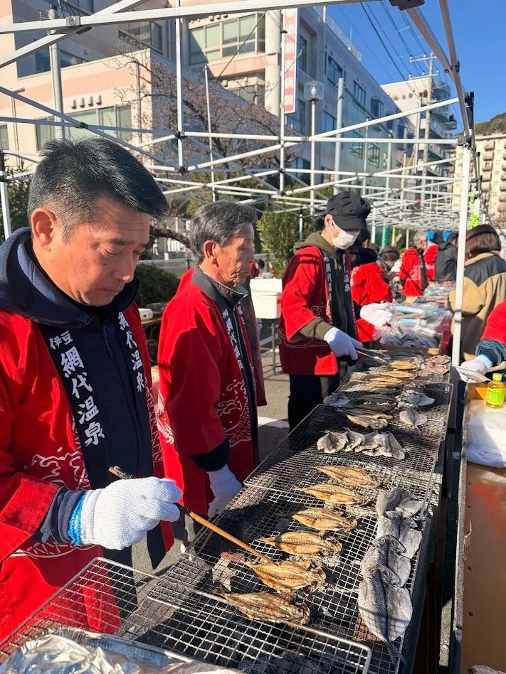 網代温泉の法被を着て干物を焼く人々
